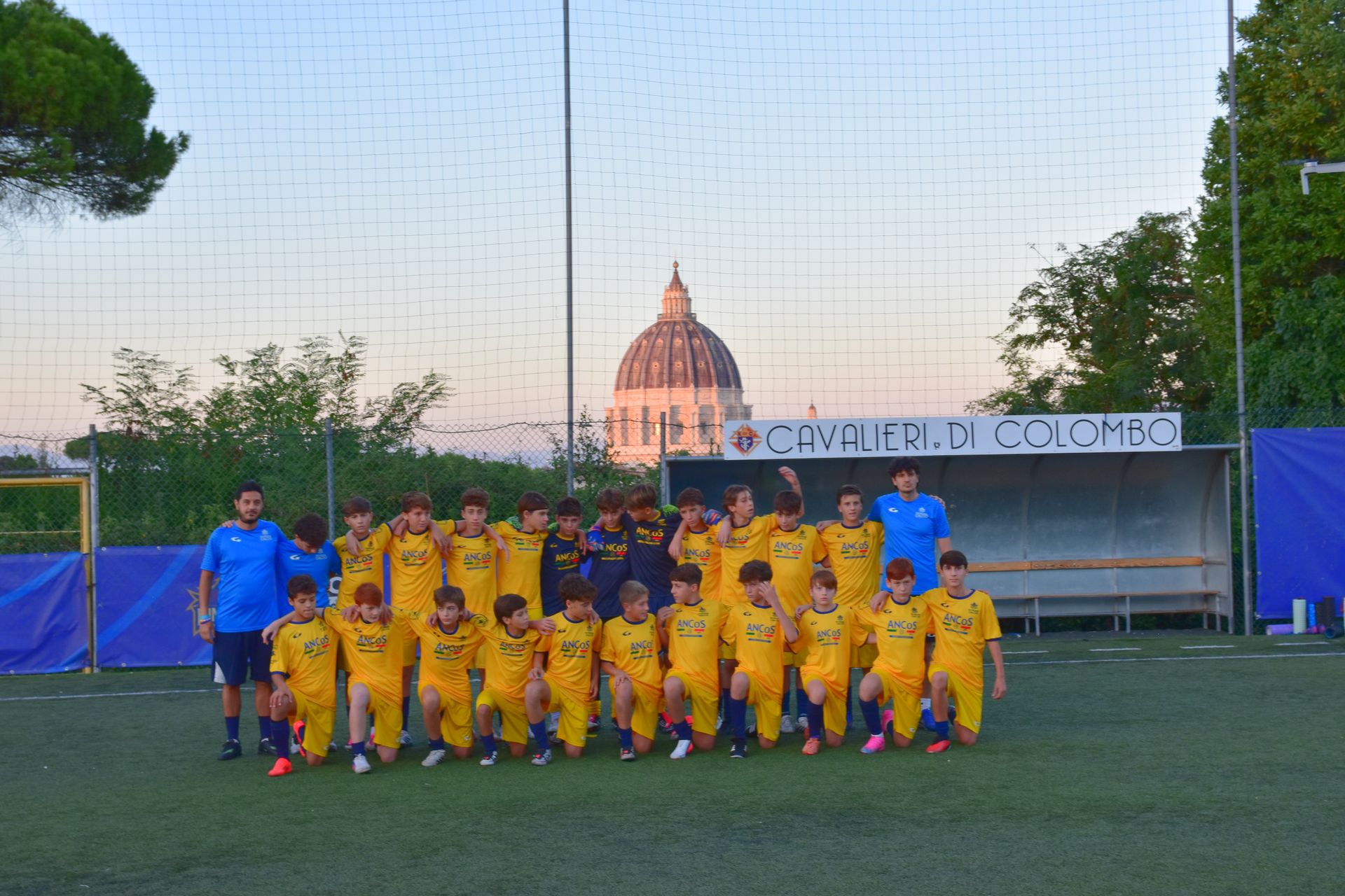 Foto di squadra al Campo Pio XI, con la Cupola di San Pietro al tramonto